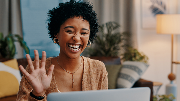 Woman with laptop waving